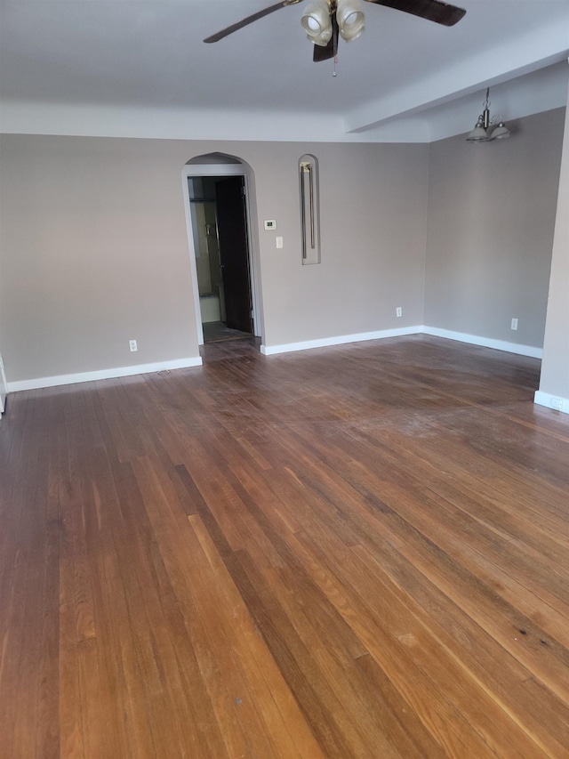 empty room with ceiling fan and dark hardwood / wood-style flooring