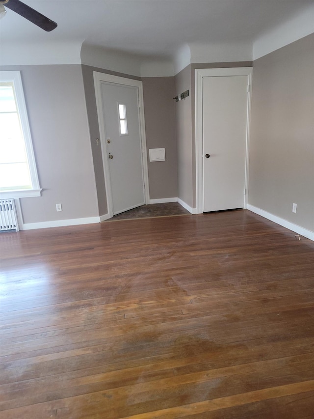 foyer featuring dark hardwood / wood-style flooring, radiator heating unit, and ceiling fan