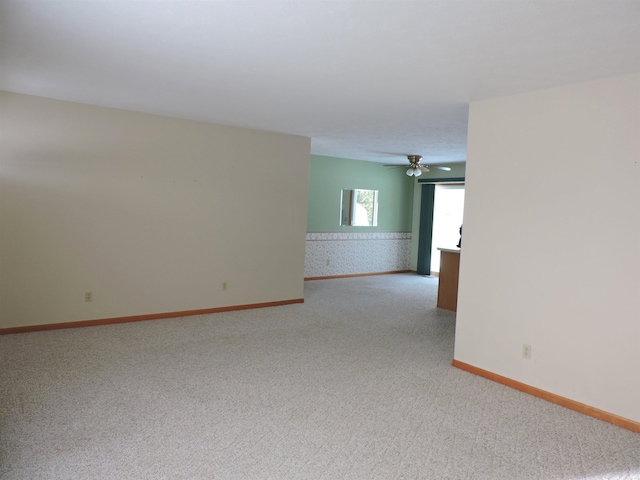 spare room featuring light colored carpet and ceiling fan