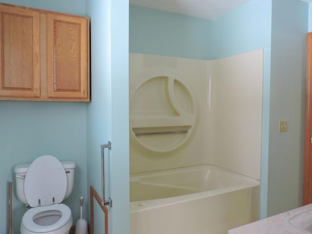 bathroom with a washtub and toilet