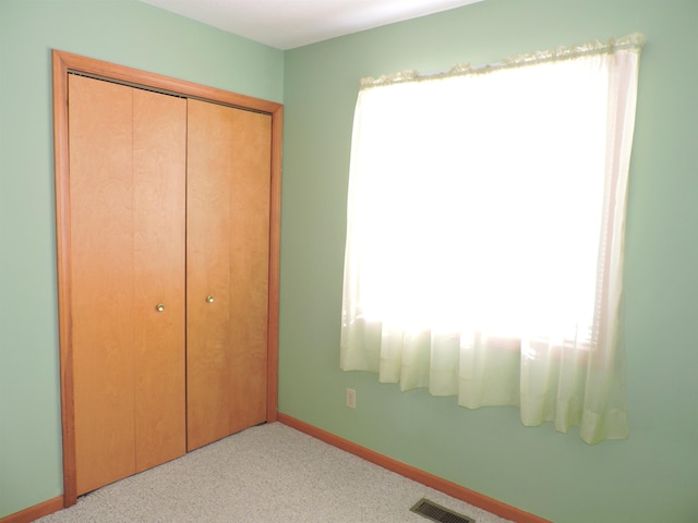 unfurnished bedroom featuring light colored carpet and a closet