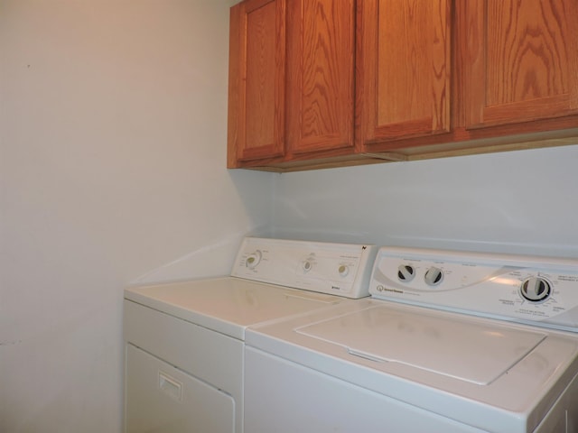 washroom featuring cabinets and washer and clothes dryer