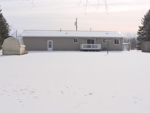 snow covered property featuring a shed