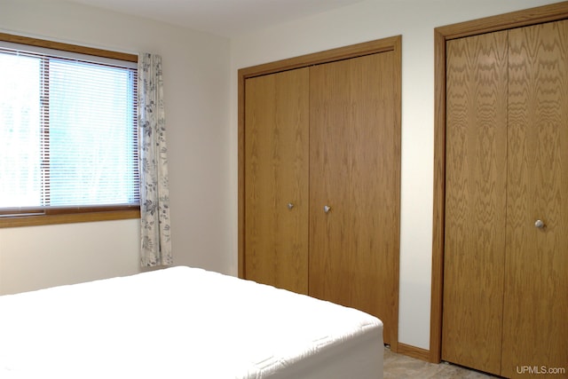 unfurnished bedroom featuring multiple closets