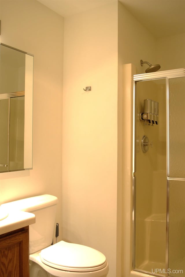 bathroom with walk in shower, vanity, and toilet