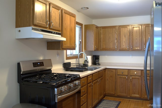 kitchen with sink, light wood-type flooring, and appliances with stainless steel finishes