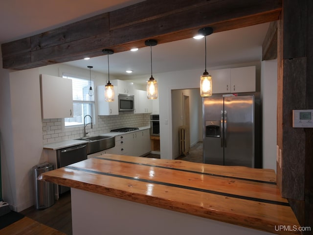 kitchen featuring pendant lighting, sink, stainless steel appliances, white cabinets, and wood counters