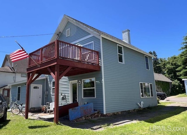 rear view of house with a yard and a deck