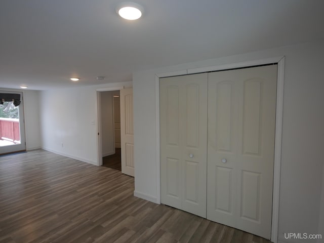 unfurnished bedroom featuring dark wood-type flooring and a closet