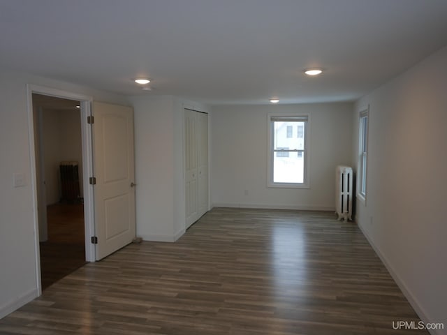 unfurnished room with radiator and dark hardwood / wood-style flooring