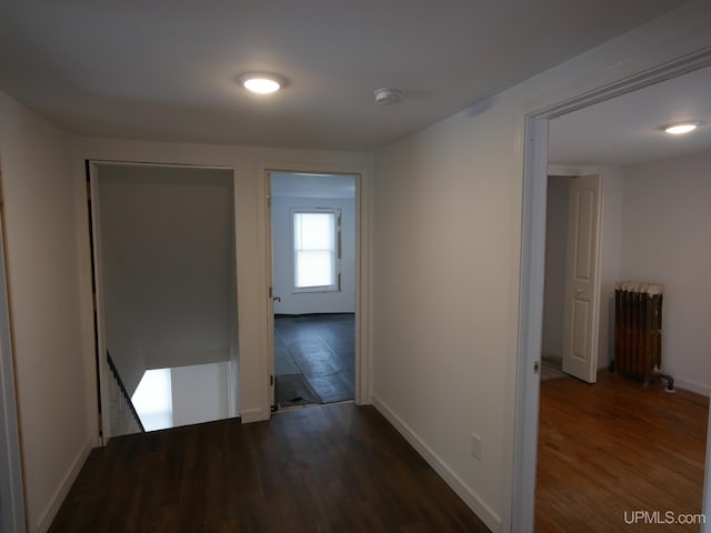 corridor featuring radiator and dark wood-type flooring