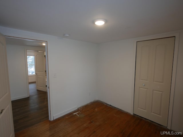 unfurnished room with dark hardwood / wood-style flooring