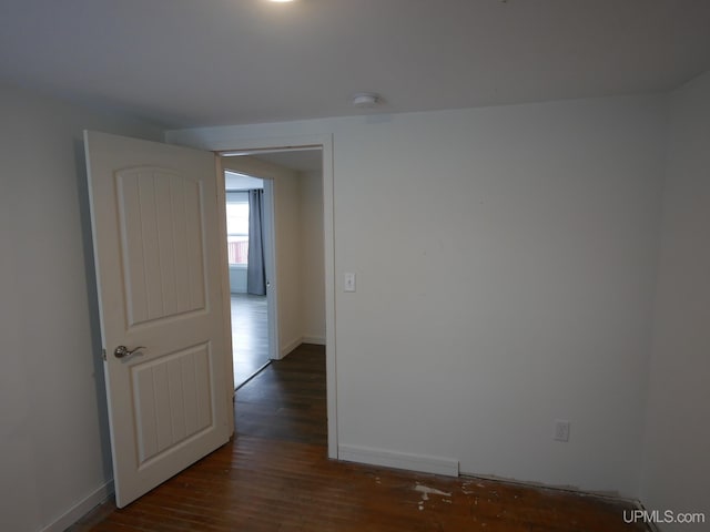 unfurnished room featuring dark wood-type flooring