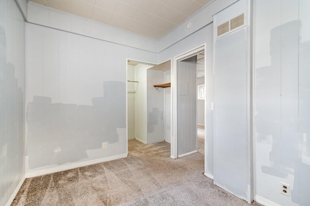 unfurnished bedroom featuring light colored carpet and a closet