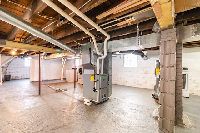 basement with heating unit, washer / clothes dryer, and electric water heater