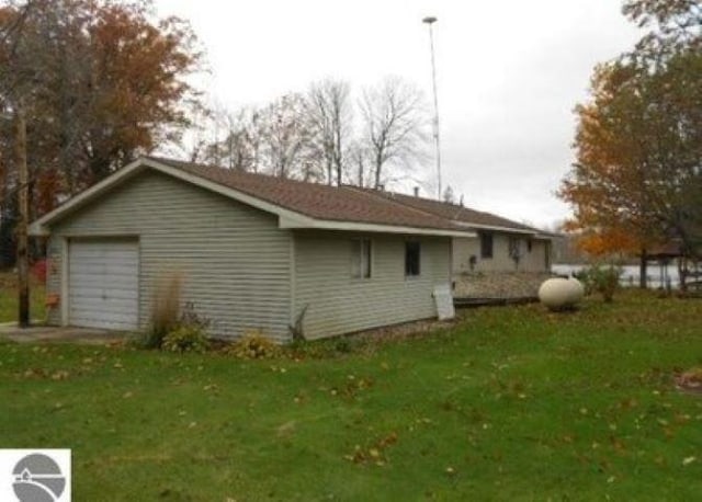 view of side of home with a garage and a yard