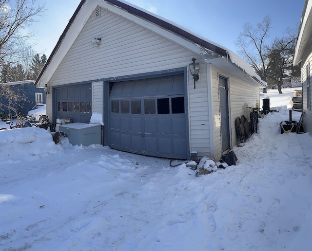 snow covered garage with a garage