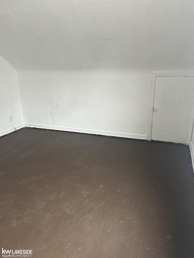 bonus room featuring hardwood / wood-style flooring, vaulted ceiling, and a textured ceiling