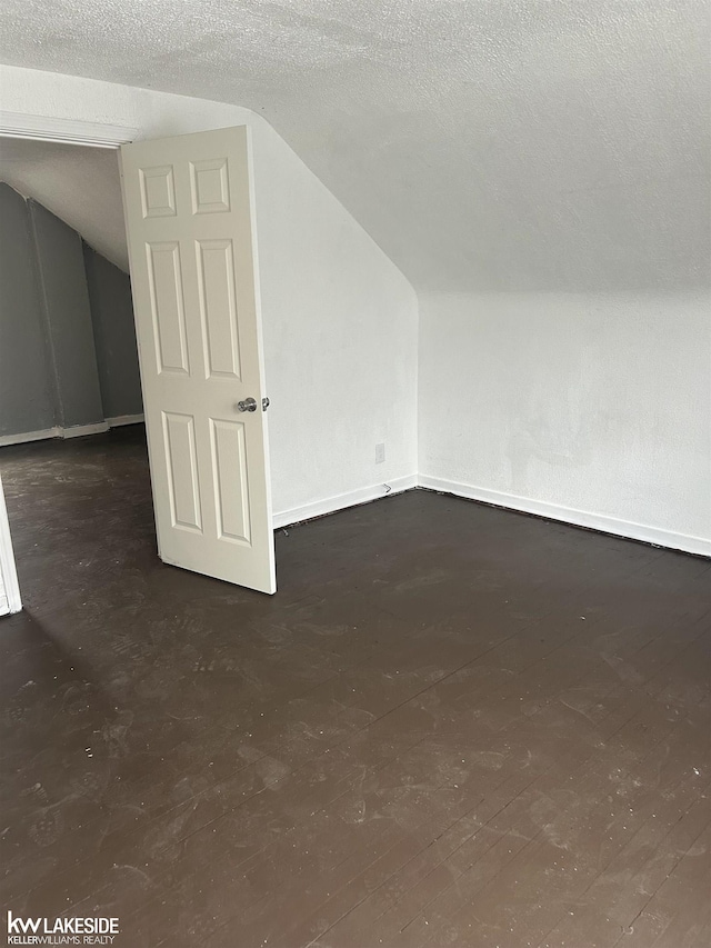 bonus room with vaulted ceiling and a textured ceiling