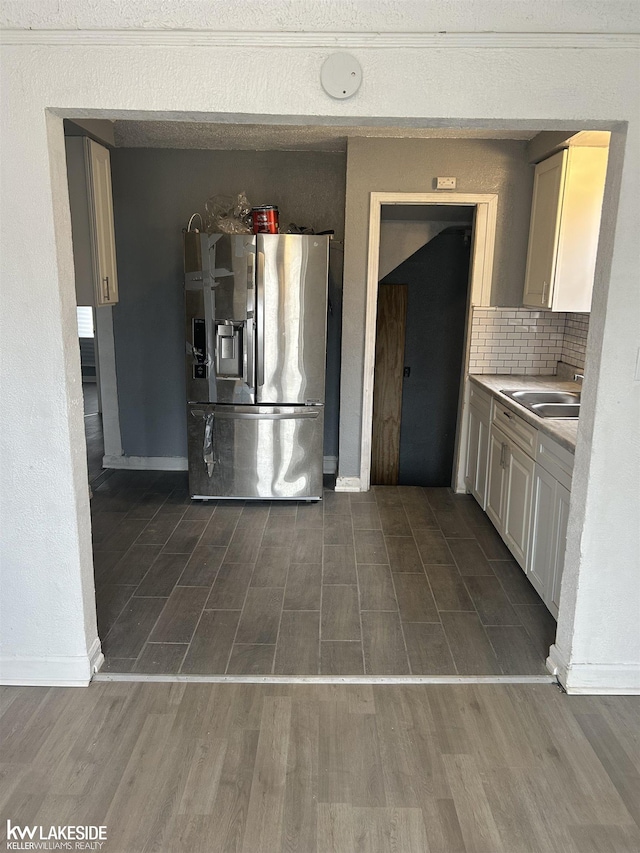 kitchen featuring sink, dark hardwood / wood-style flooring, stainless steel fridge with ice dispenser, and decorative backsplash