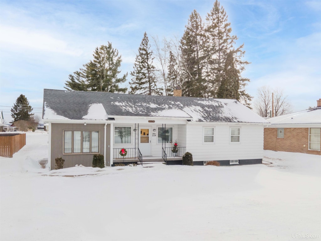 view of snow covered back of property