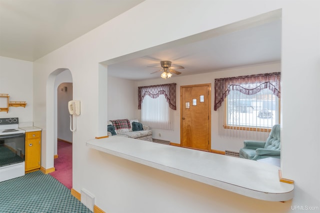 kitchen featuring white electric stove, ceiling fan, and carpet flooring