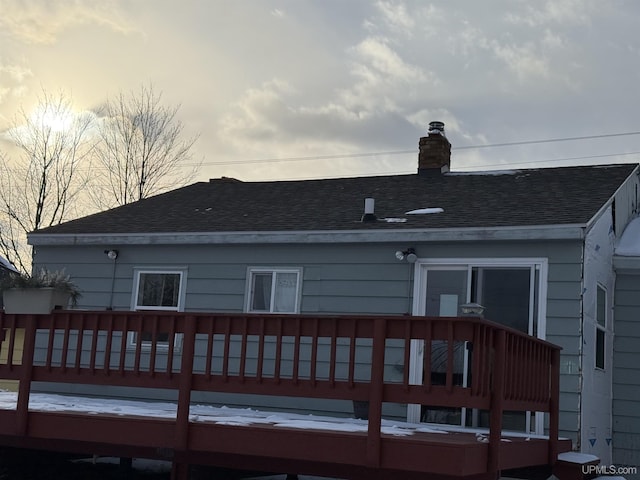 back house at dusk with a deck