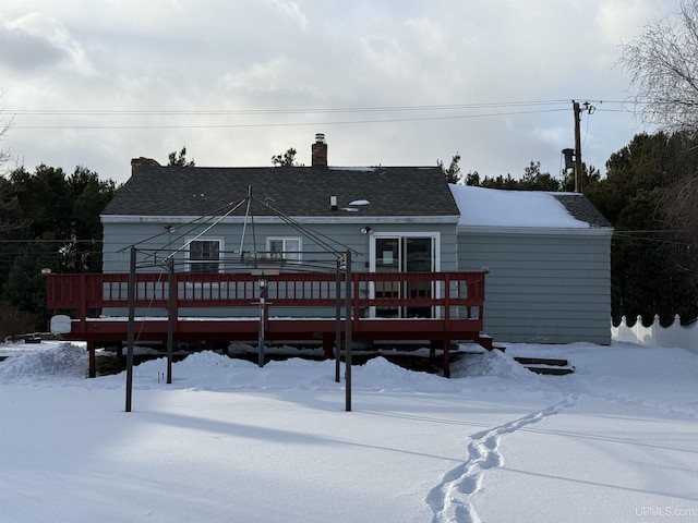 snow covered house featuring a wooden deck