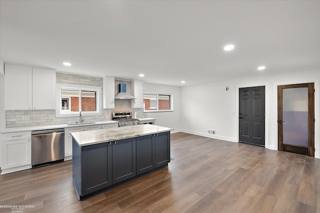 kitchen featuring white cabinetry, hardwood / wood-style flooring, a kitchen island, and appliances with stainless steel finishes