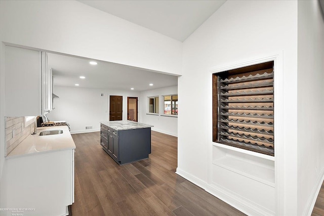 interior space featuring dark wood-type flooring, white cabinetry, gray cabinets, and sink