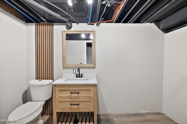 bathroom featuring vanity, wood-type flooring, and toilet