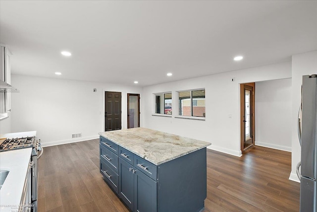 kitchen featuring stainless steel appliances, dark hardwood / wood-style flooring, a center island, and white cabinets