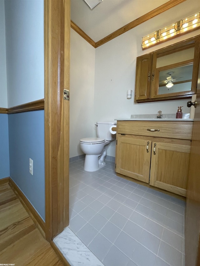 bathroom with ceiling fan, tile patterned flooring, vanity, ornamental molding, and toilet