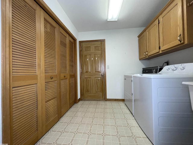 clothes washing area featuring washer and clothes dryer and cabinets