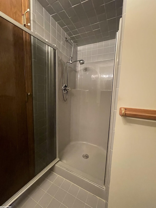 bathroom featuring tile patterned flooring and a shower with shower door