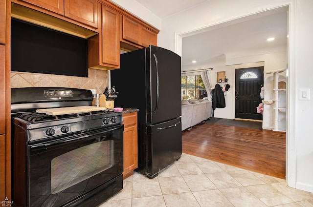 kitchen with light tile patterned floors, decorative backsplash, and black appliances