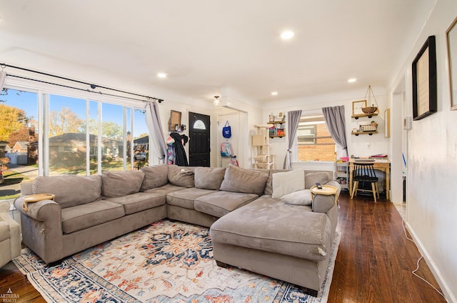 living room with plenty of natural light and dark wood-type flooring