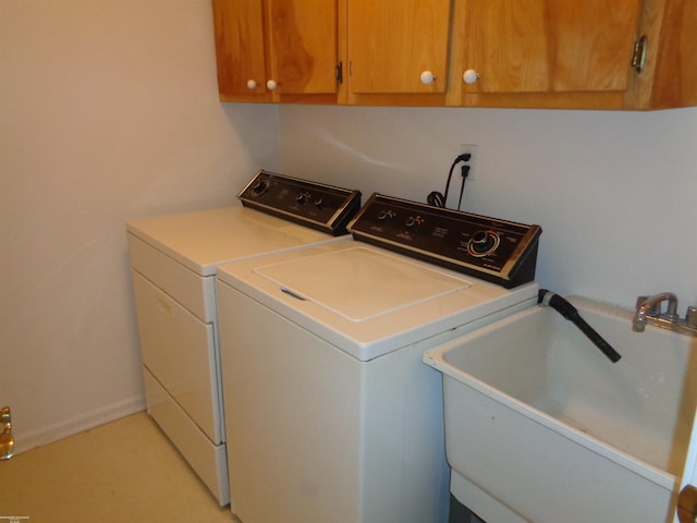 washroom featuring cabinets, sink, and washer and dryer