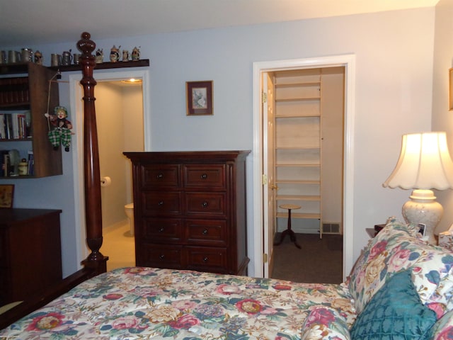 bedroom with carpet floors and connected bathroom