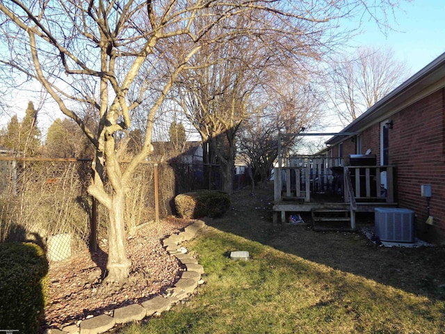 view of yard with a wooden deck and central air condition unit