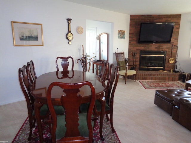 dining room with a fireplace and light wood-type flooring