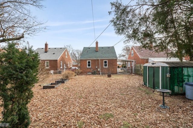 rear view of property featuring cooling unit and a shed