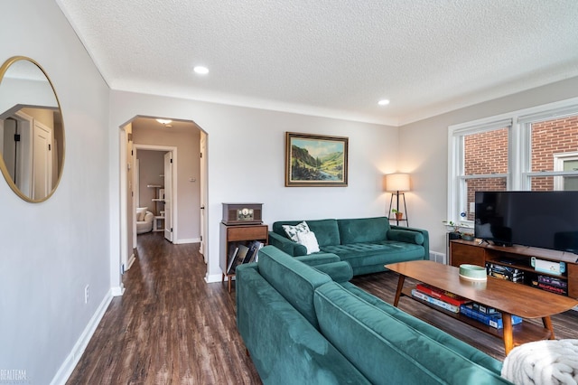 living room with dark wood-type flooring and a textured ceiling