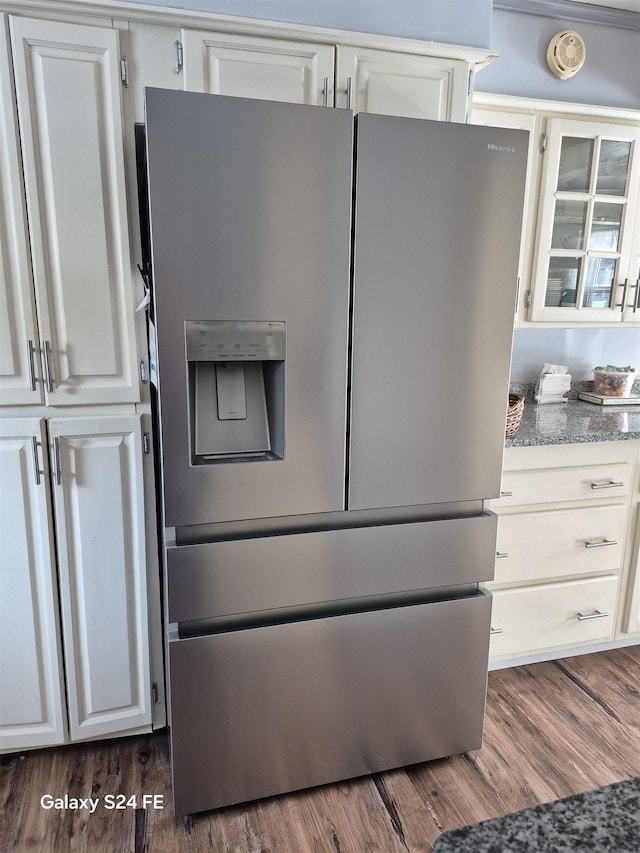 kitchen featuring white cabinetry, dark wood-type flooring, stainless steel fridge with ice dispenser, and light stone counters