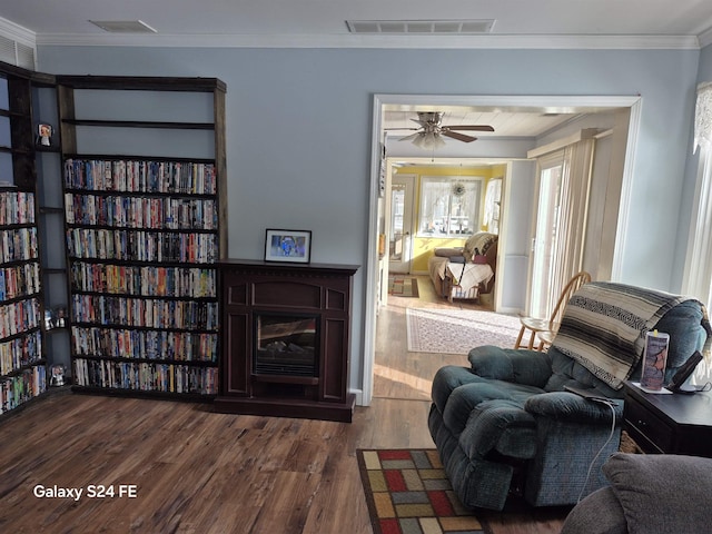 sitting room featuring hardwood / wood-style flooring, ceiling fan, and ornamental molding