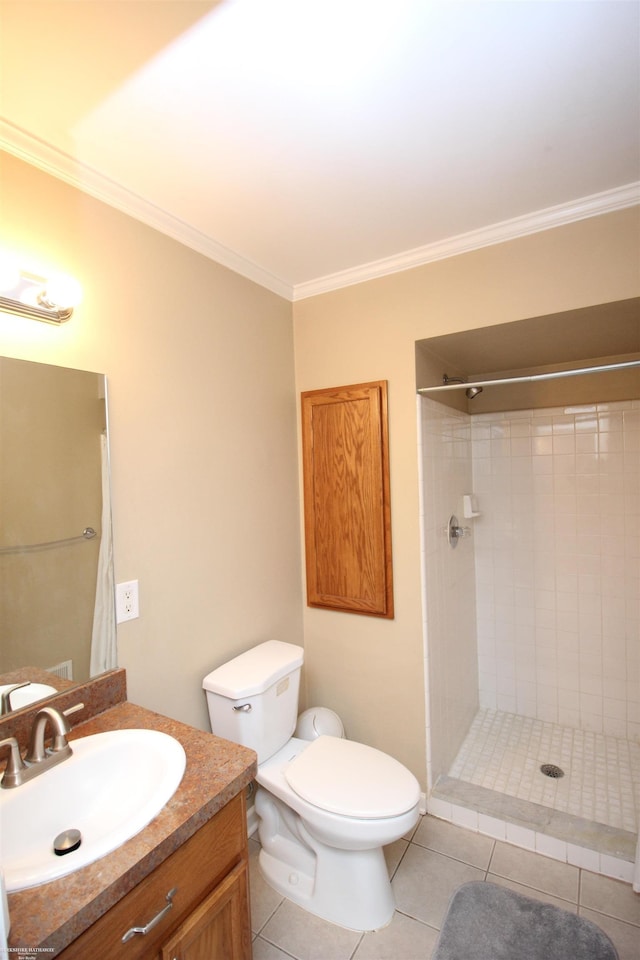 bathroom featuring a tile shower, crown molding, tile patterned floors, and toilet