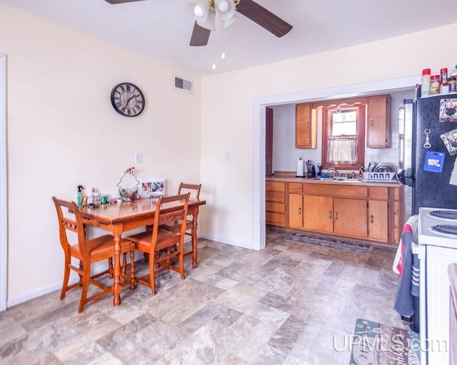 dining room with ceiling fan and sink