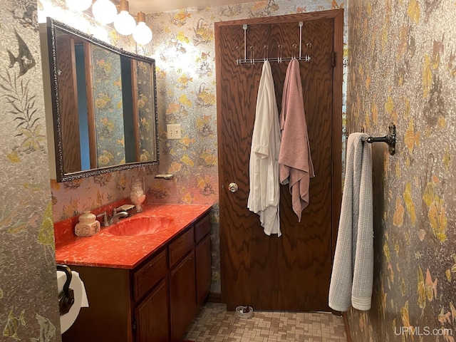 bathroom with vanity and wallpapered walls