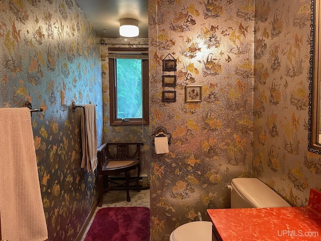 half bath with toilet and wallpapered walls