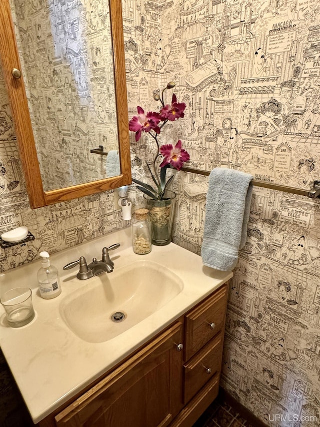 bathroom featuring vanity and wallpapered walls